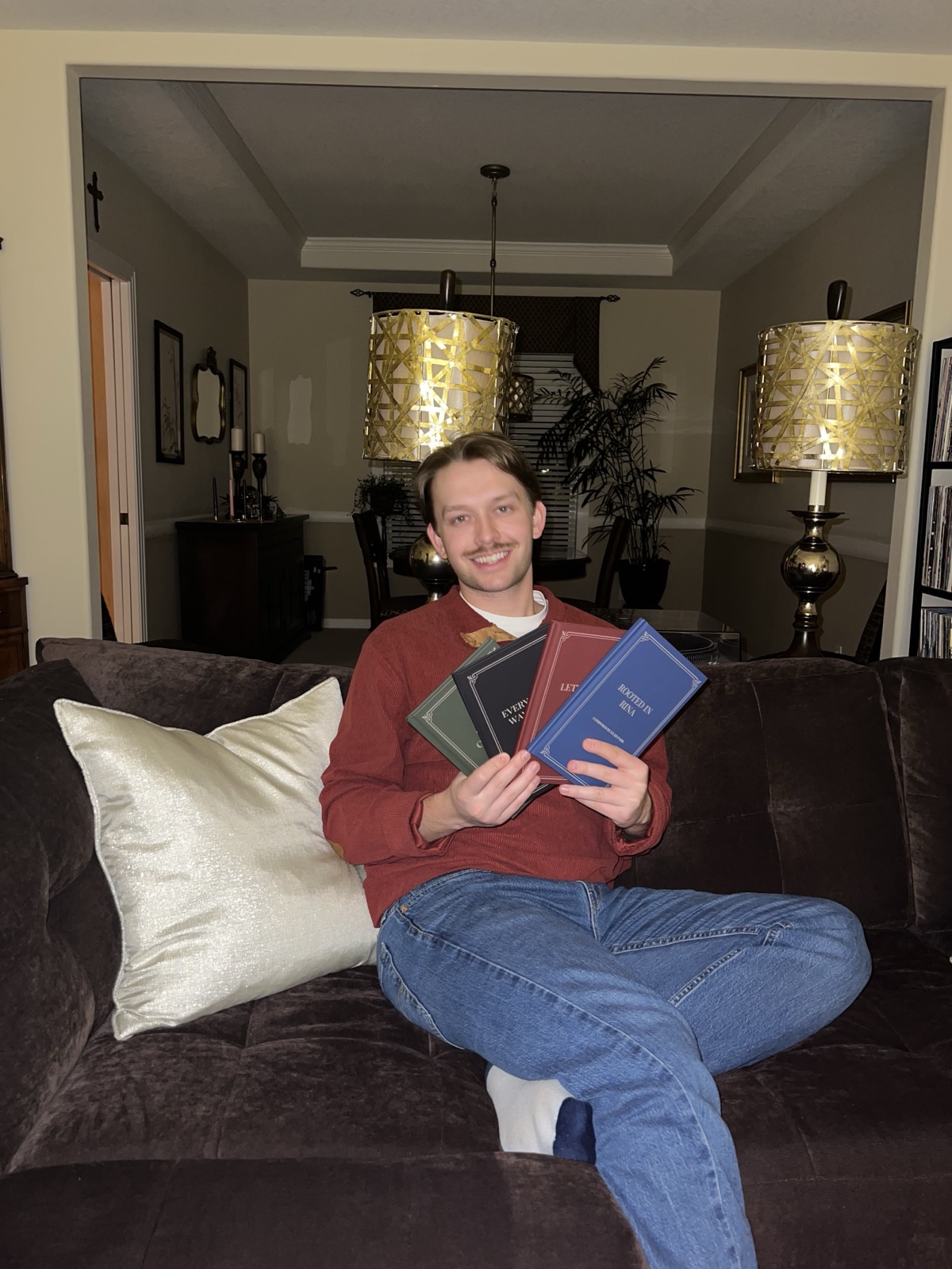 Tanner seated with ApolloPoet books.
